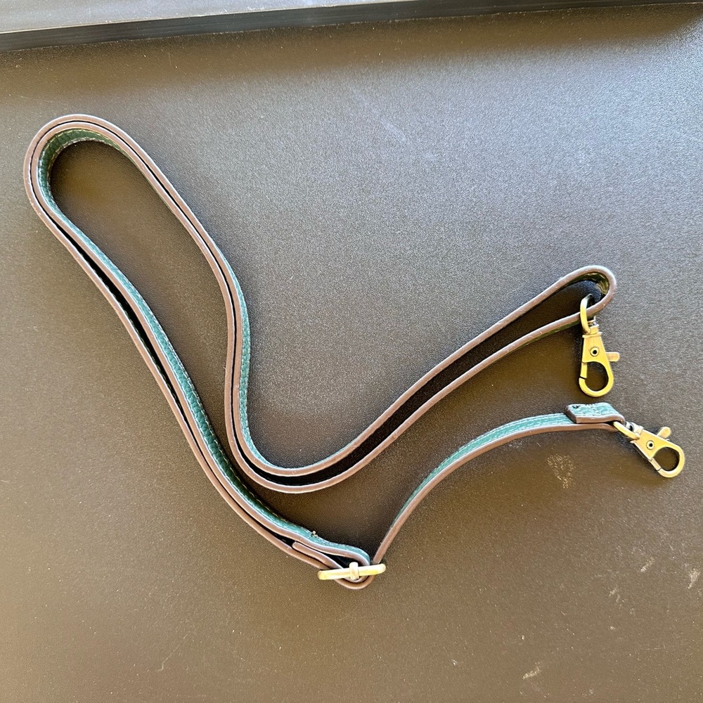 Green purse strap with gold tone lobster clip.